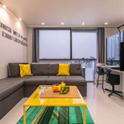 The living room, a large sofa, a 100 inch TV, a large balcony, french window, has a good view. The living room is 60 square meters, with a dining table. There are green plants, flowers, and a mahjong table next to it in the living room